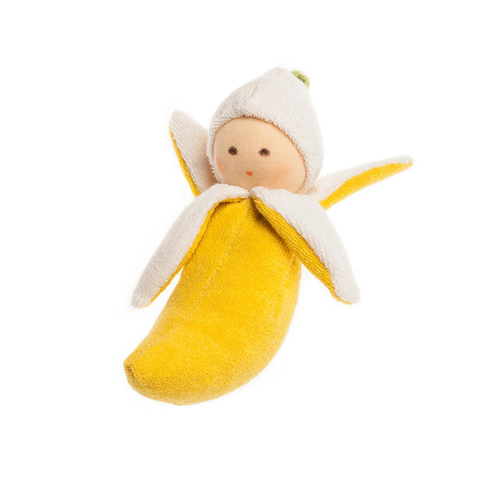 Nanchen Natur Banana Rattle — handmade Waldorf rattle nestled inside a yellow terry cloth banana with peeled white segments, hand-painted face, on white background