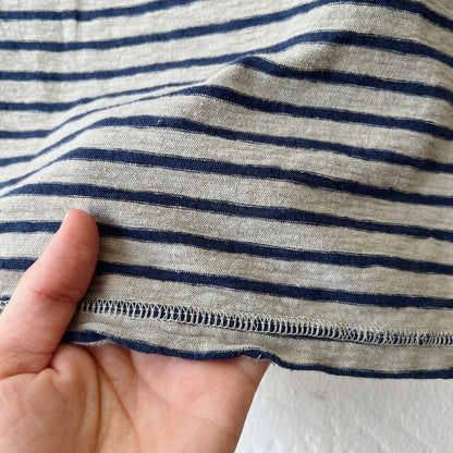 Close-up of a hand holding fabric with green and black stripes.