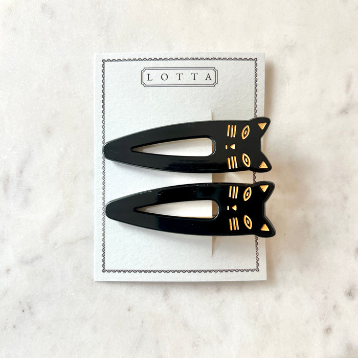 Lotta Cat Duo Clips in Black on their Lotta branded card — two black cellulose acetate snap clips with gold-etched cat-face tops, on a marble surface