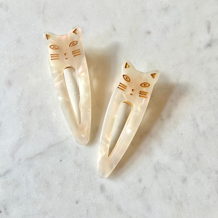 Cat-shaped hair clips on a marble surface