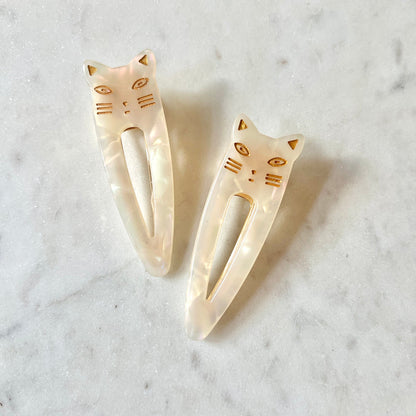 Cat-shaped hair clips on a marble surface