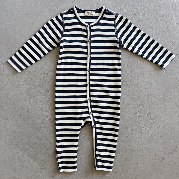 Black and white striped baby onesie on a gray background