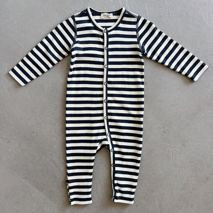 Black and white striped baby onesie on a gray background
