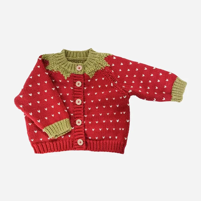 Red cotton knit baby cardigan with white heart pattern, olive green yoke and ribbed cuffs, and pink buttons, shown flat on a white background.