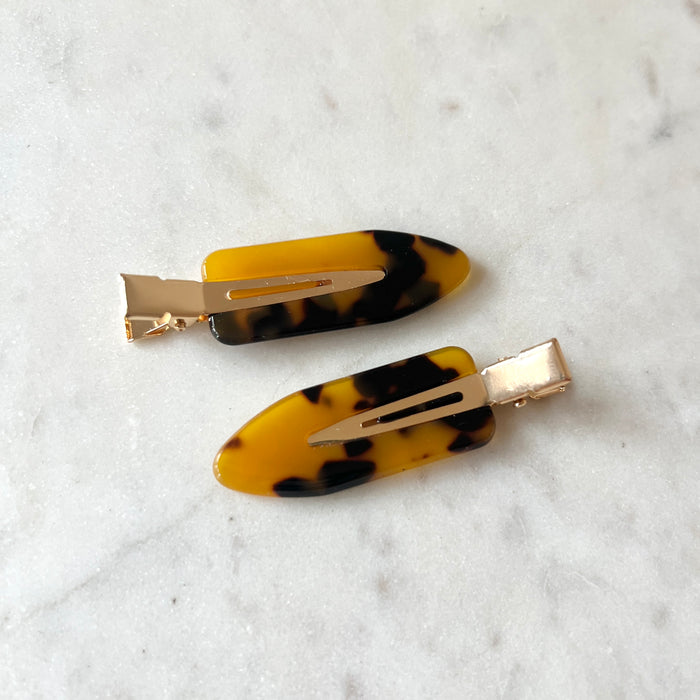 Two tortoiseshell hair clips on a white background