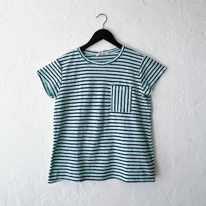 Striped t-shirt with a pocket on a hanger against a white wall