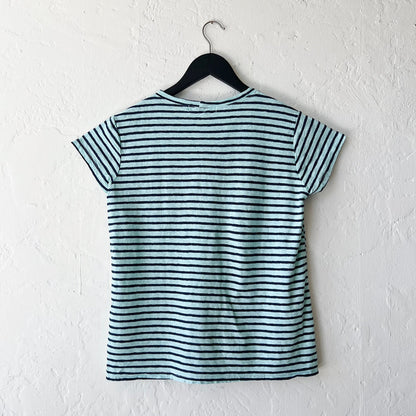 Striped t-shirt on a hanger against a white wall, viewed from the back.