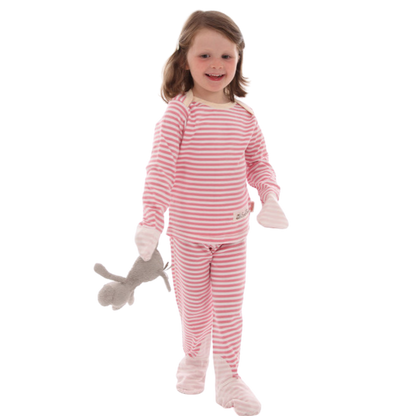 Toddler girl holding stuffed animal and wearing pink and white striped Scratchsleeves pajamas for eczema prone skin.