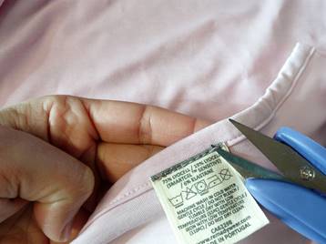 Showing how to cut the tag seam to remove the clothing tag.