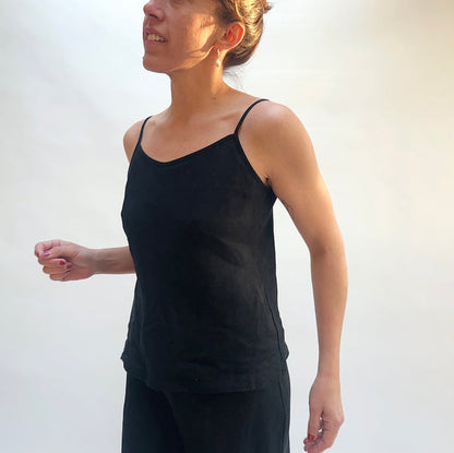 Person wearing a black tank top against a white background