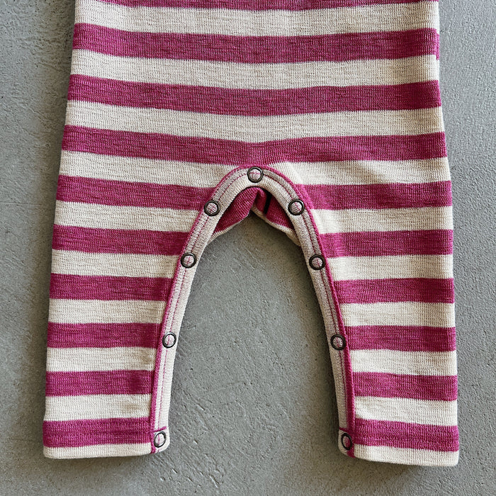 Striped baby romper with buttons on a gray background