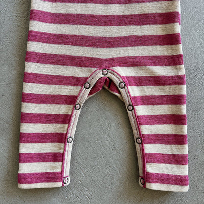 Striped baby romper with buttons on a gray background