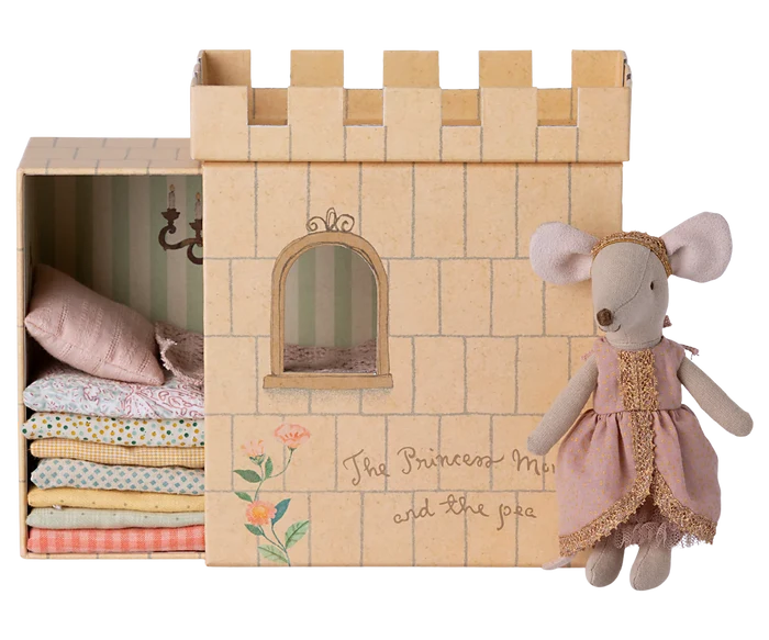 Maileg Princess and the Pea Big Sister Mouse — cotton princess mouse doll in a pink dot dress with gold lace trim and gold headband, standing beside the illustrated castle box with stacked fabric mattresses visible inside